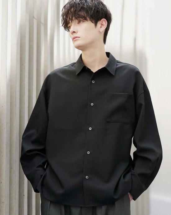 ASTRONOMYの黒い長袖シャツを着た20代の男性