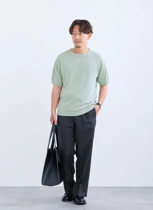 明るい色のニットに黒のパンツを合わせた40代のコーデ