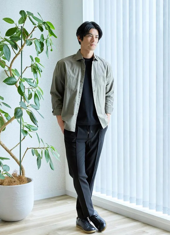 カーキのシャツに黒のパンツを合わせた50代のコーデ